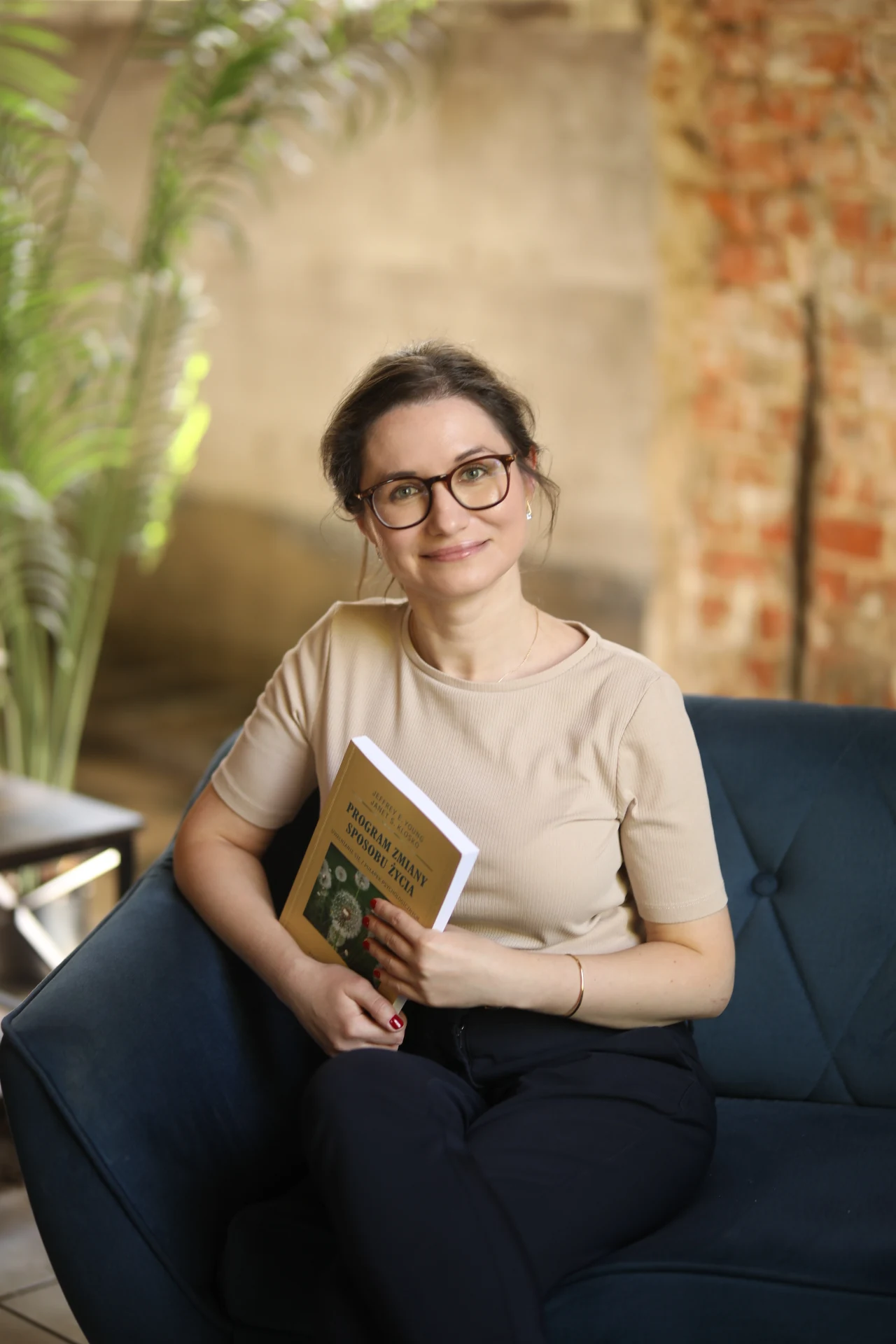 Magdalena Żurawska siedząca z książką w gabinecie